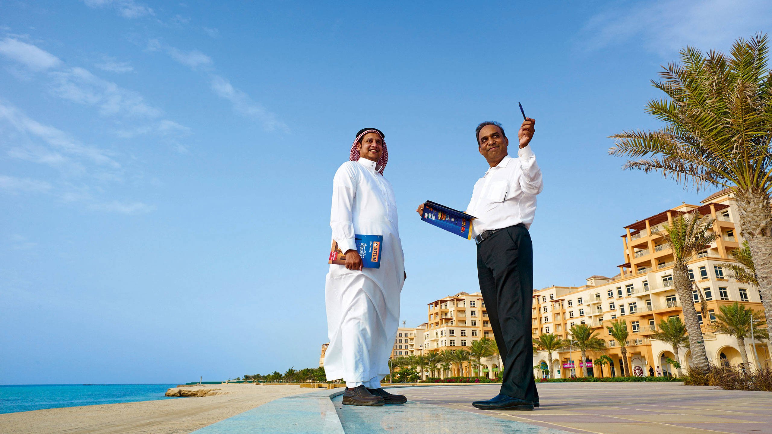 Two salesmen from the Middle East having a chat and smiling