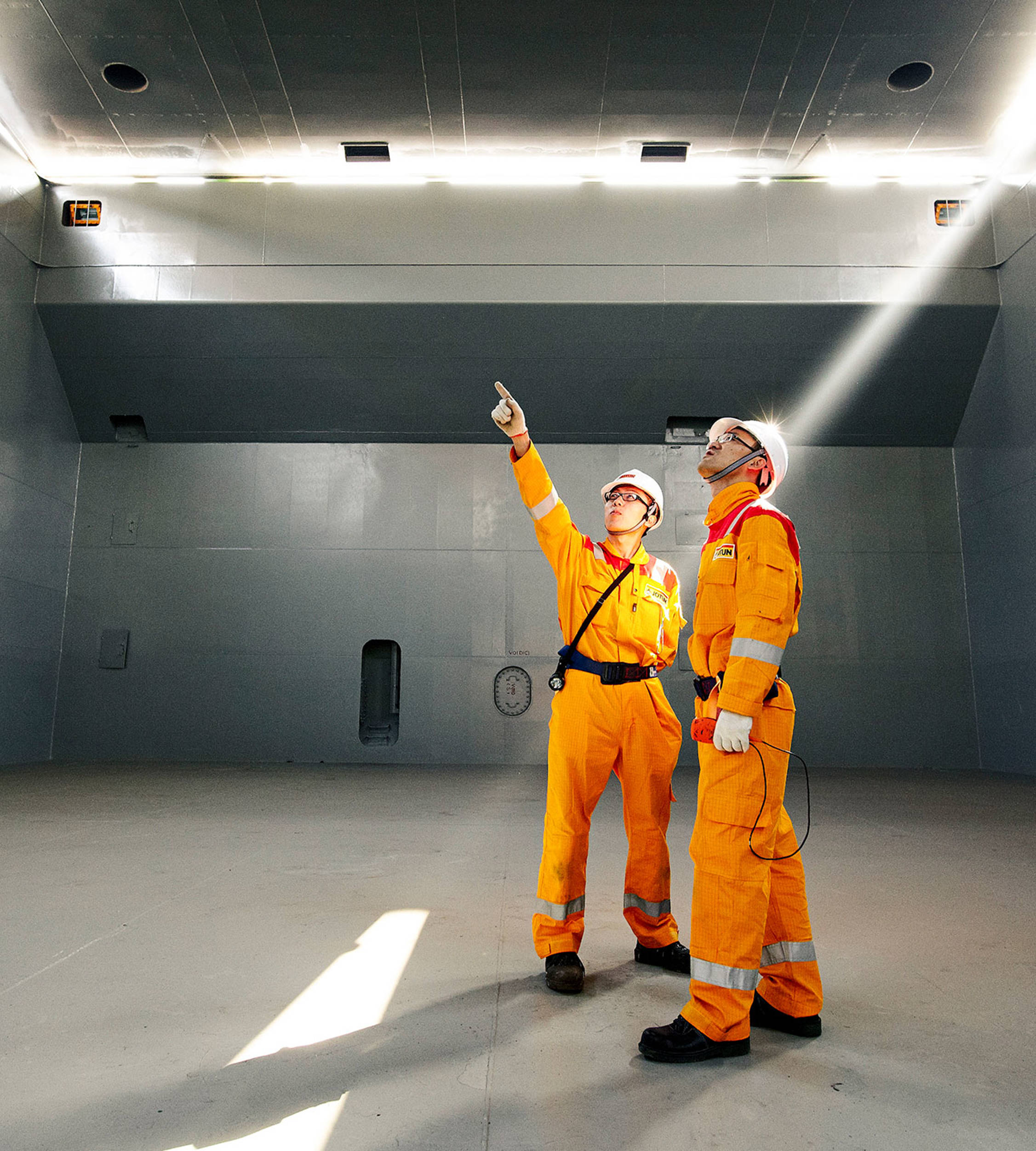 Two members of Jotun's Technical Service team inside a ship hull