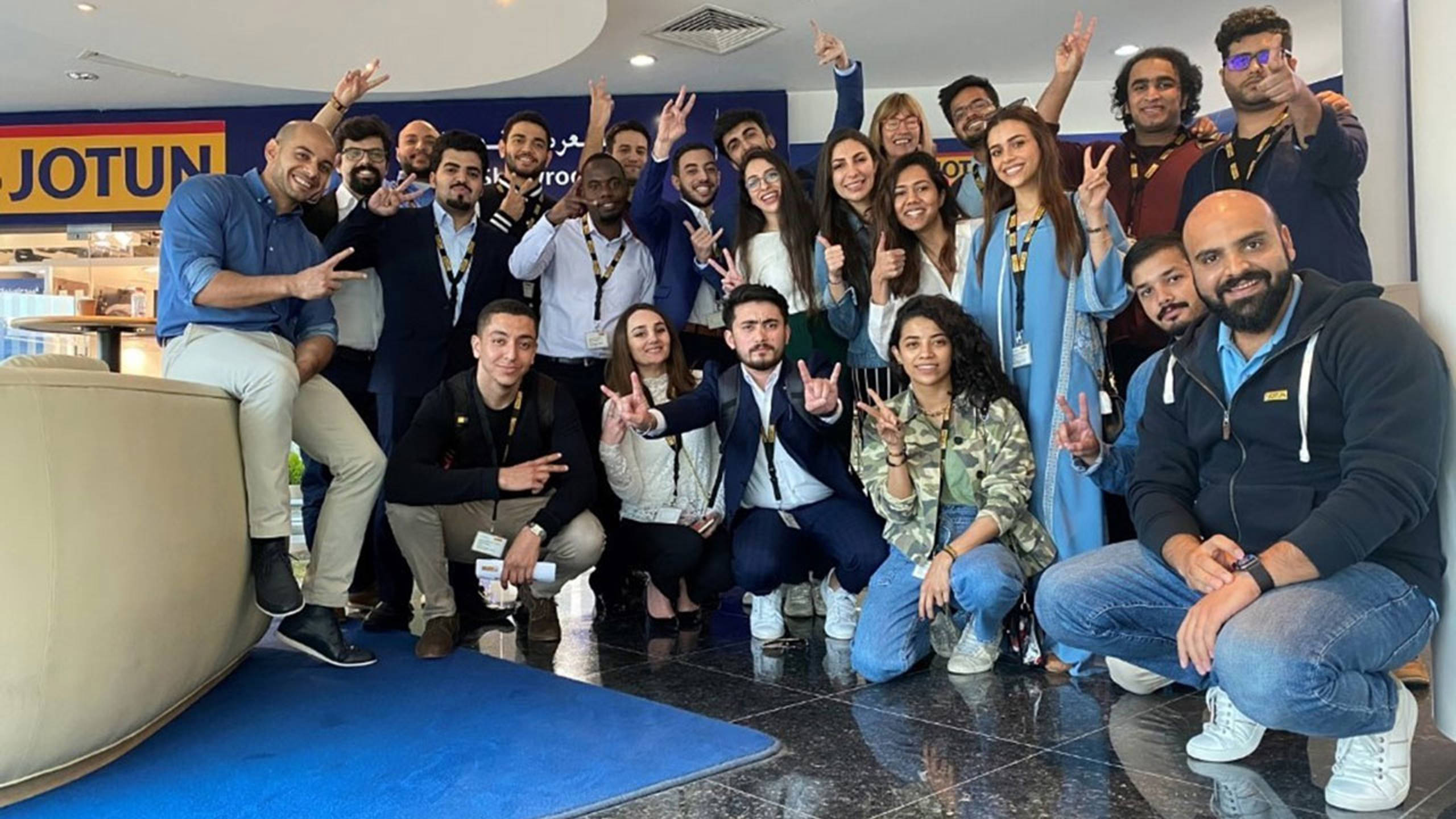 Graduates cheering after completing a Jotun graduate program